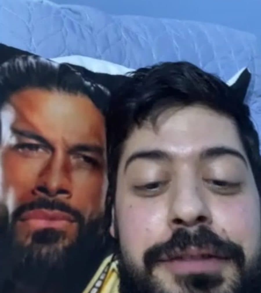 Doumit in bed next to a Roman Reigns pillow